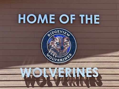 Home of the Wolverines lettering with mosaic tile wolverine logo